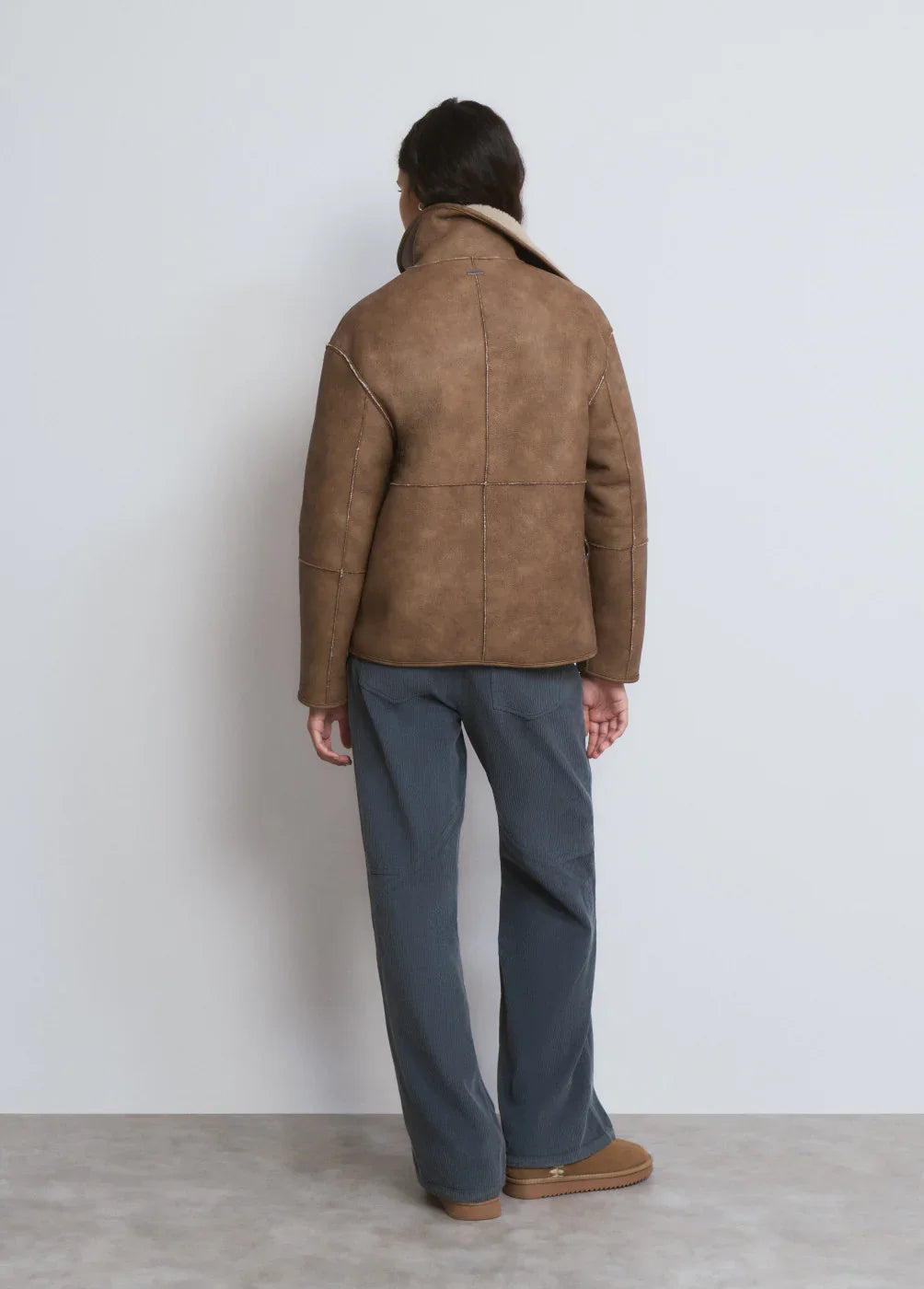 דגם לייף סטייל של CHOZEN, אישה בחליפת ז'קט חום ומכנסיים כהים, צילום אחורי, אופנה עדכנית