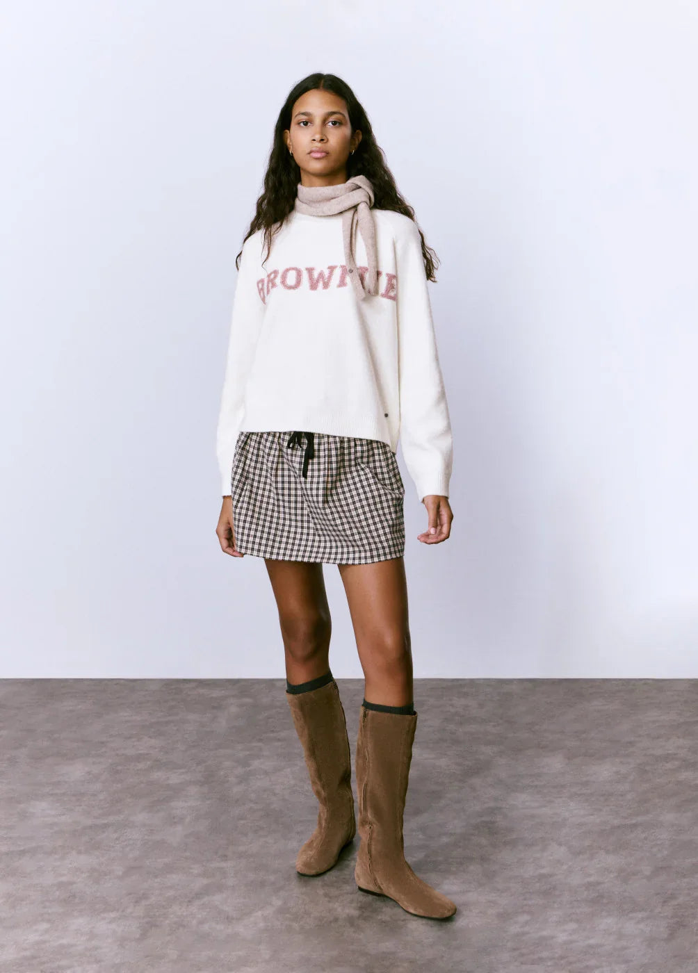 דוגמנית עם סוודר לבן BROWNIE, חצאית משובצת, מגפיים חומים, אופנת חורף CHOZEN
