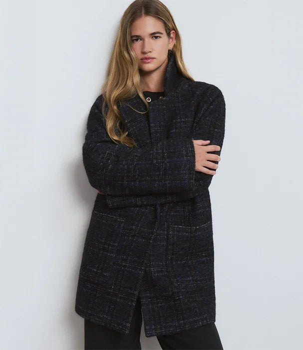 אישה חובשת מעיל צמר כהה אופנתי, רקע לבן, אופנה יוקרתית ב-CHOZEN