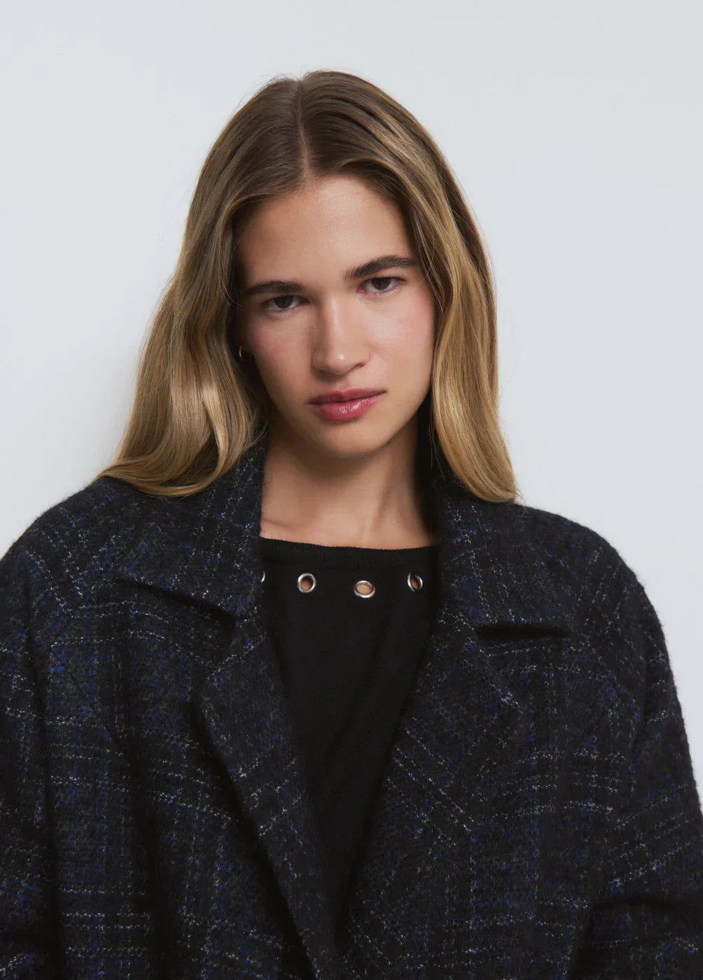 דוגמנית לובשת מעיל קלאסי בצבע כחול כהה משובץ מבית CHOZEN, צילום אופנה בסטודיו