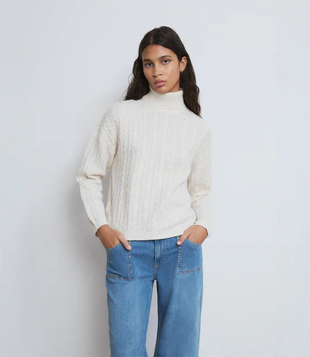 דוגמנית לובשת סוודר גולף לבן ומכנסי ג'ינס כחולים רקע לבן באתר CHOZEN