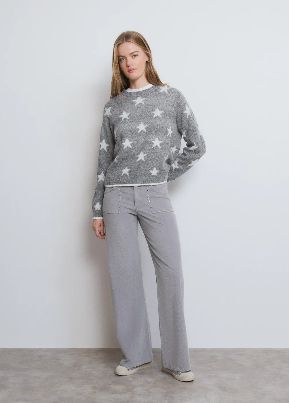 דוגמנית לובשת סוודר אפור עם כוכבים לבנים ומכנסיים רחבים אפורים, אופנה עלית CHOZEN