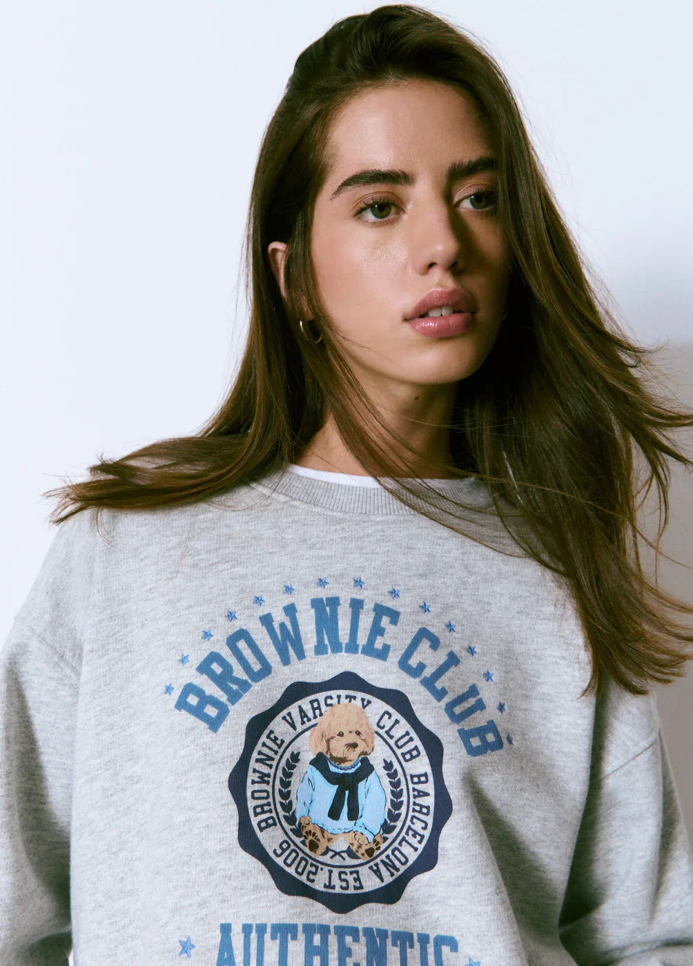 דוגמנית לובשת סווטשירט אפור עם הדפס כלב חום וטקסט BROWNIE CLUB, צילום אופנה באתר CHOZEN
