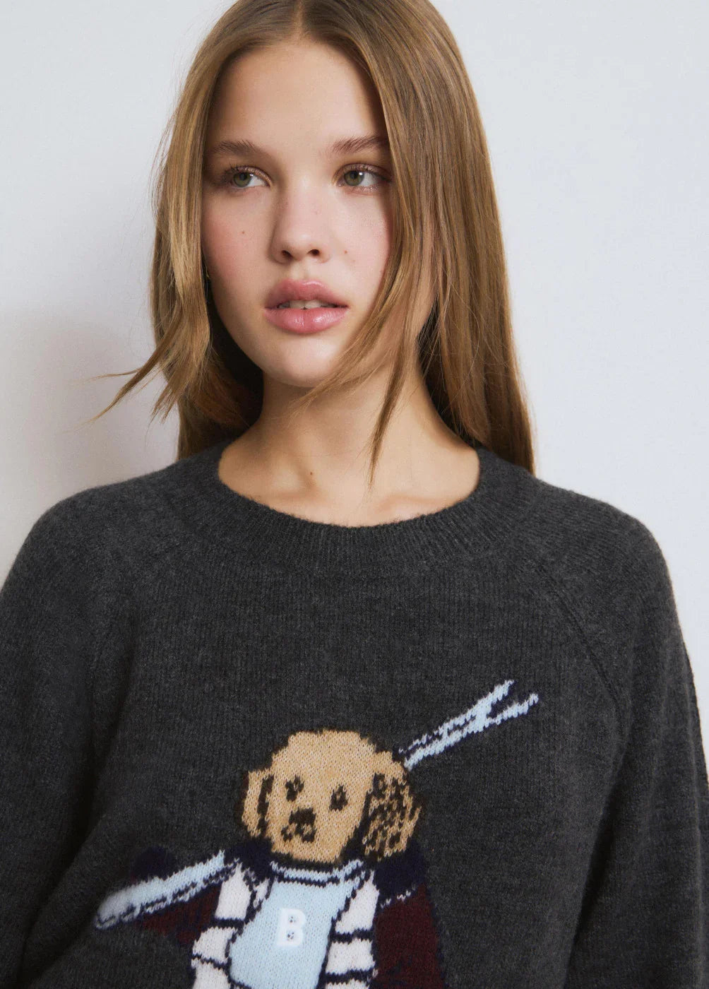 דוגמנית צעירה עם סוודר אפור מעוטר דוב מצויר, אופנת נשים CHOZEN