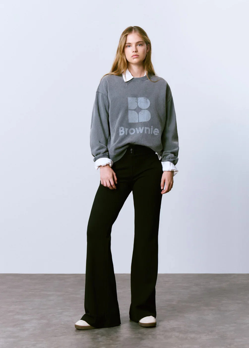 דוגמנית לובשת סווטשירט אפור של Brownie ומכנסיים שחורים, אופנה לנשים ב-CHOZEN
