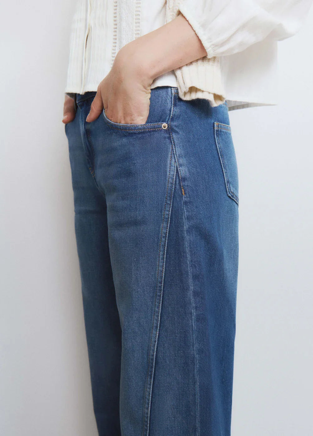 תקריב מכנסי ג'ינס כחולים במראה יומיומי, חולצה לבנה, אופנה עדכנית מבית CHOZEN