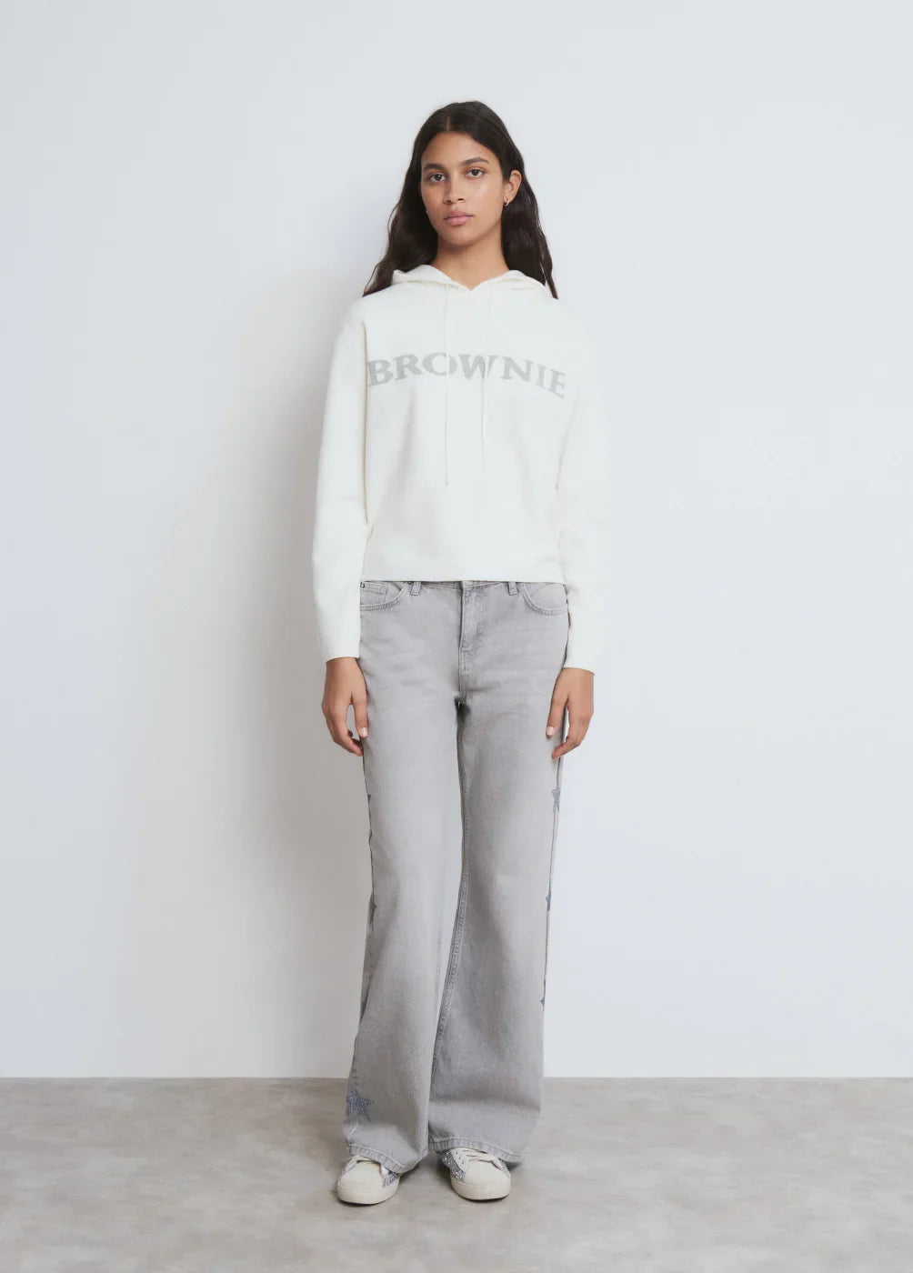 דוגמנית עם סווטשירט לבן BROWNIE ומכנסי ג’ינס אפורים, אופנה לנשים CHOZEN