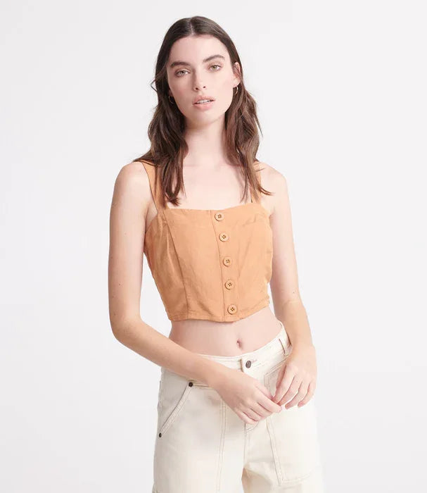 דוגמנית בחולצת קרופ כתומה עם כפתורים ומכנסי ג'ינס בהירים, צילום אופנה לאתר CHOZEN