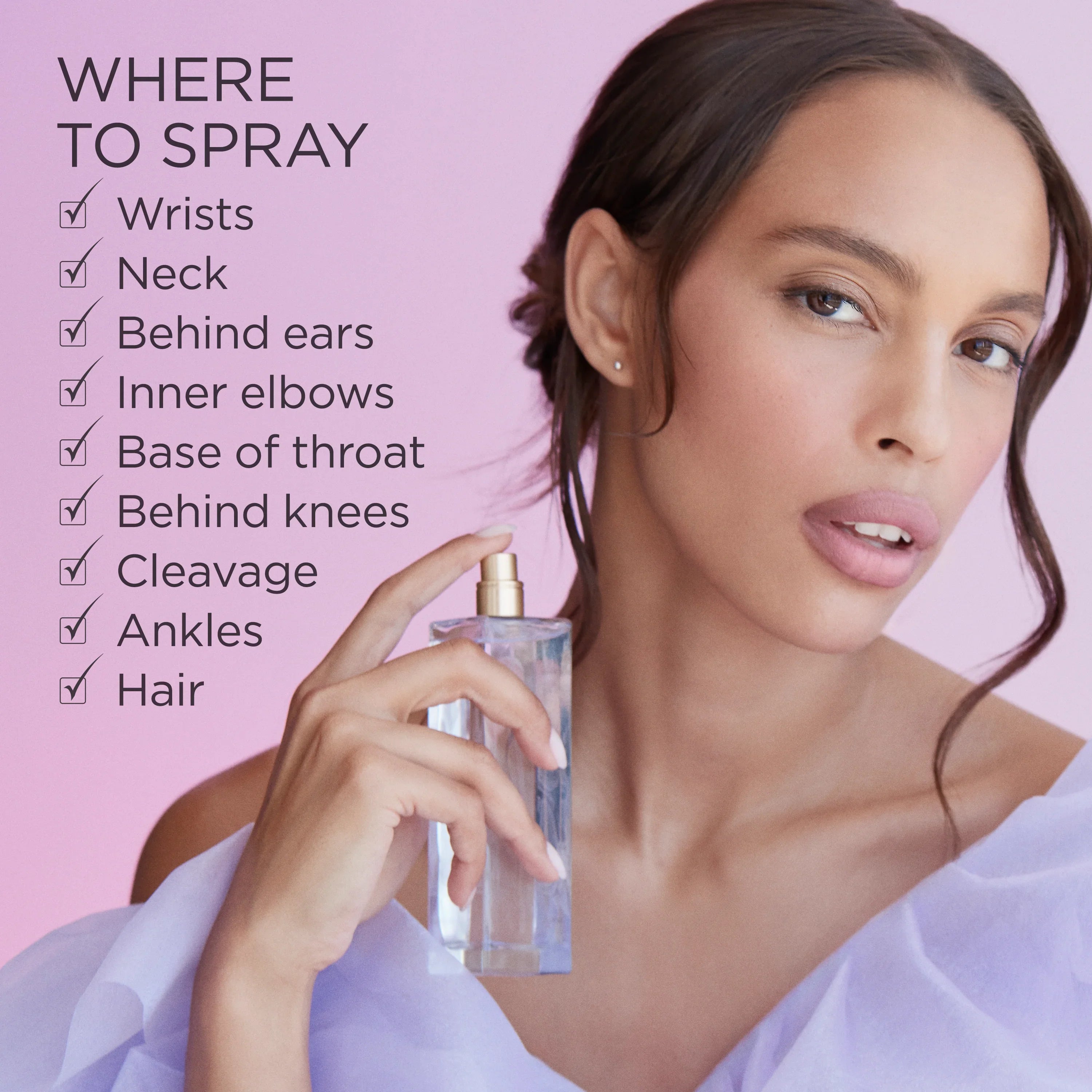 אישה מחזיקה בקבוק בושם על רקע ורוד עם טיפים לריסוס, קמפיין CHOZEN