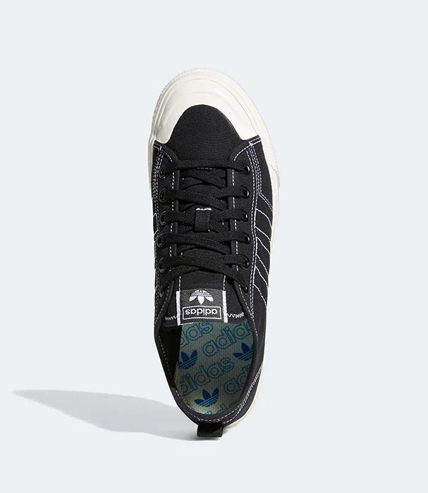 נעל סניקרס אדידס שחורה עם כיפת גומי לבנה, צילום על רקע אפור, ב-CHOZEN