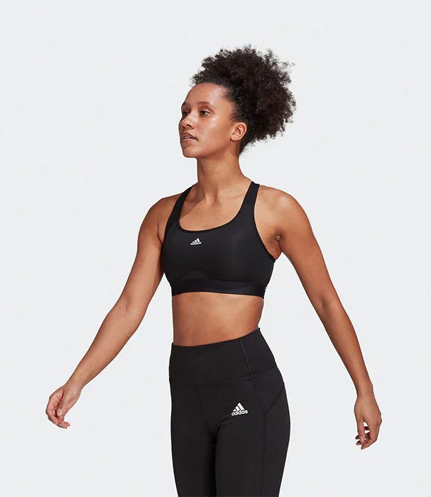 אישה לובשת טופ וספורט טייץ שחורים של אדידס בולבן, אופנת ספורט CHOZEN