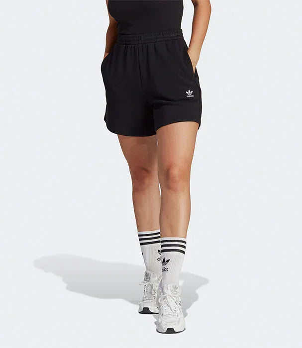 מכנסי ספורט שחורים לנשים עם לוגו אדידס, גרביים ונעלי ספורט לבנות, רקע לבן