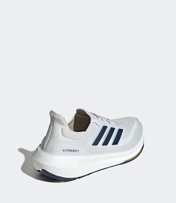 נעל ספורט לבנה עם שלושה פסים שחורים, adidas ultraboost, צילום צד על רקע אפור, CHOZEN