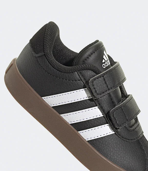 נעל ספורט אדידס שחורה עם פסי לוגו לבנים, סוליה חומה, צילום תקריב לפרטי הנעל