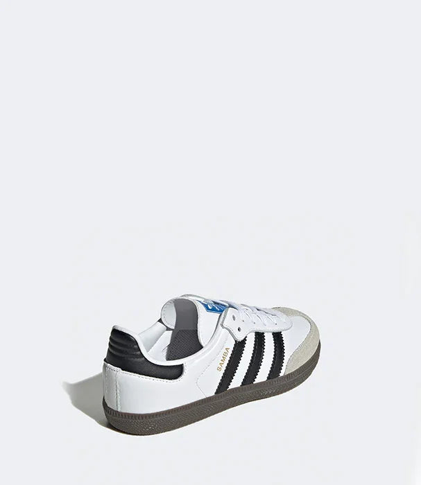 נעל סניקרס לבנה עם שלושה פסים שחורים על רקע אפור, מותג מוביל מחנות CHOZEN