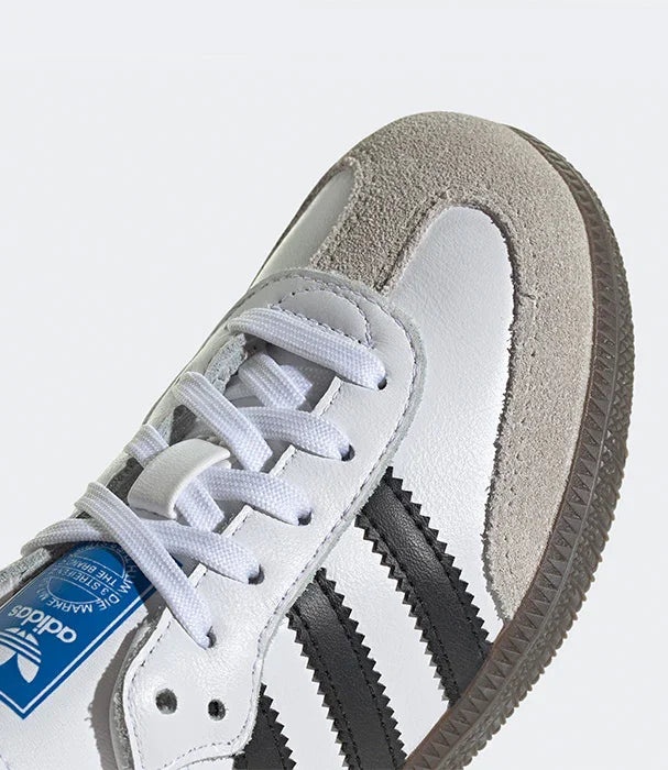 נעל ספורט אדידס לבנה עם פסים שחורים, סוליה חומה ועיצוב מודרני, ב-CHOZEN