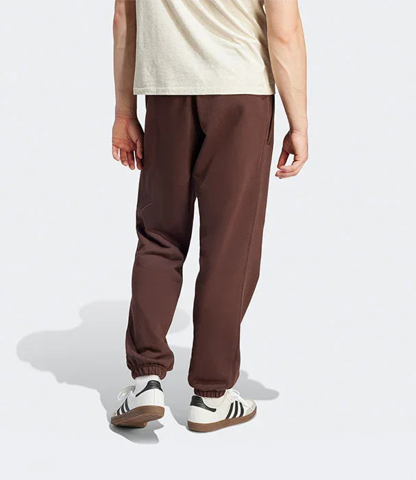 דגם לובש מכנסי ספורט חומים ונעלי סניקרס לבנות, צילום מאחור, CHOZEN מותג אופנה מוביל