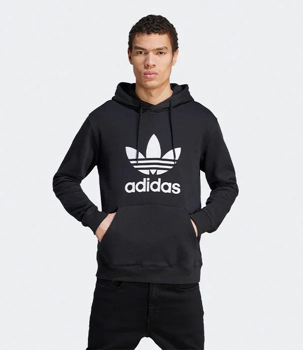 גבר לובש סווטשירט קפוצ׳ון שחור עם לוגו אדידס, צילום אופנה ל-CHOZEN