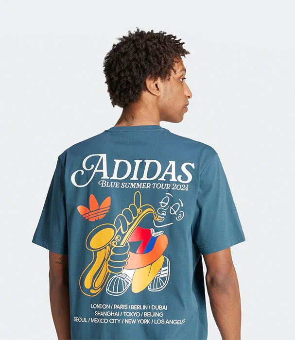 גבר לובש חולצת טי של אדידס בצבע כחול עם הדפס גרפי צבעוני על הגב, חלק מקולקציית 2024