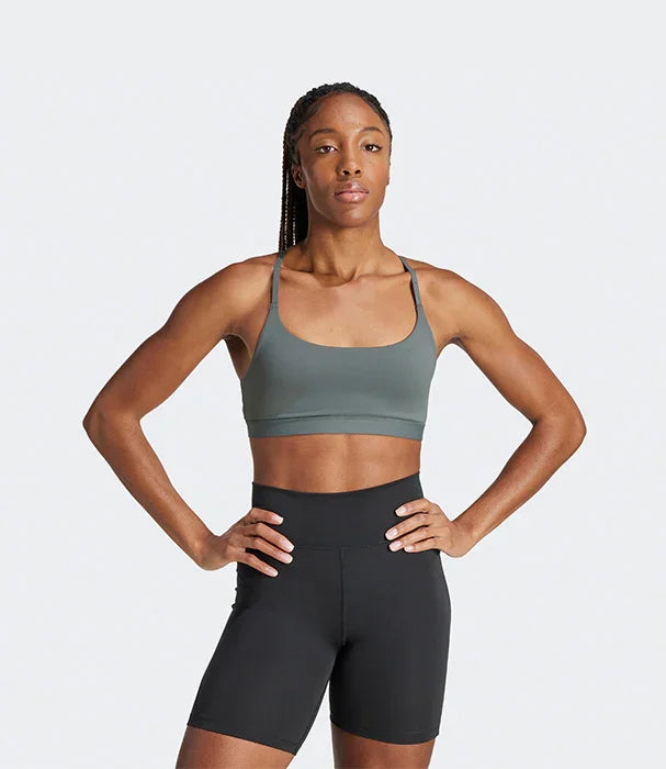 אישה בדגם ספורטיבי לובשת טופ אפור ומכנסיים קצרים שחורים, רקע לבן, CHOZEN