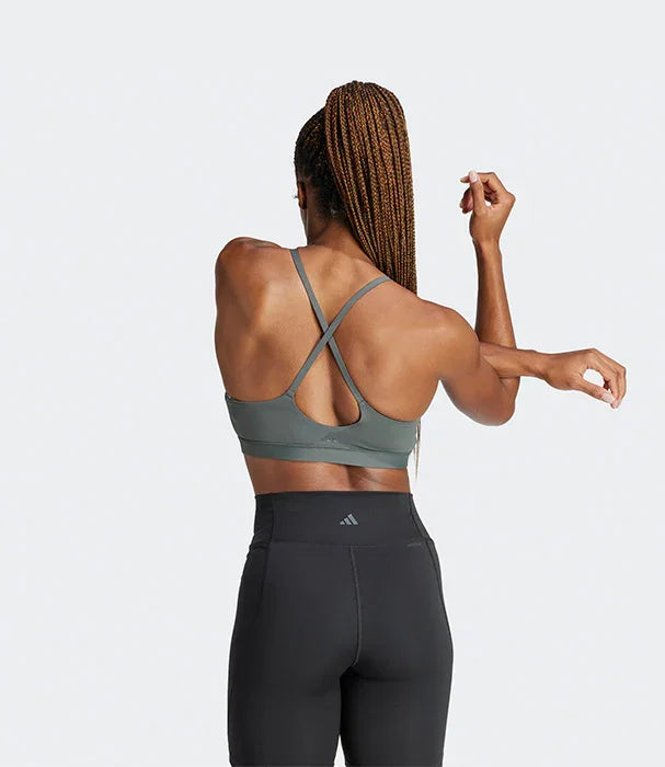 אישה לובשת טופ ספורט אפור ומכנסי ספורט שחורים, מבט מאחור, מותג CHOZEN