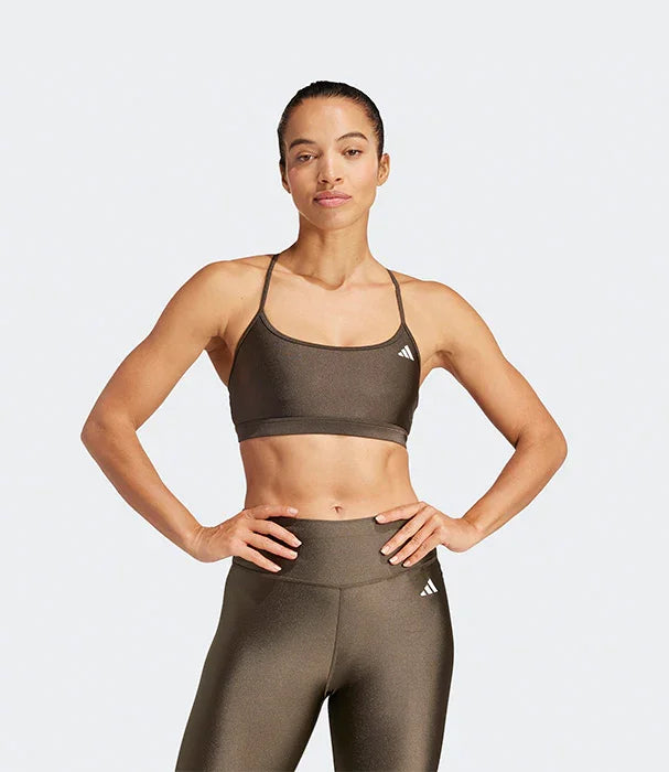 דוגמנית לובשת טופ ספורט וחותלות אדידס בגוון חום בסטודיו, אופנת ספורט CHOZEN