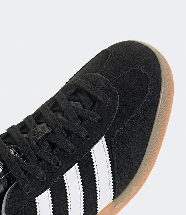 נעל ספורט שחורה עם פסי עור לבנים וסוליה בהירה, צילום תקריב, CHOZEN מותגים מובילים