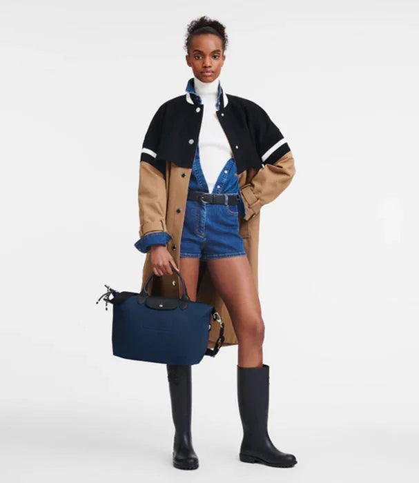 אופנה עדכנית מבית CHOZEN, דוגמנית עם מעיל אופנתי, שורט ג‘ינס, מגפיים ותיק כחול