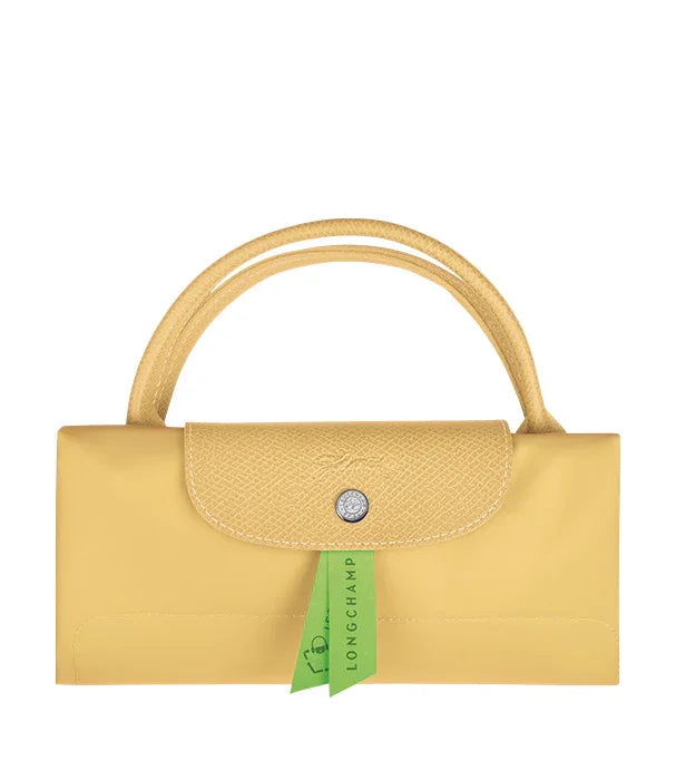 תיק נשי צהוב מתקפל LONGCHAMP עם ידית, מוצג על רקע לבן, מותגי אופנה CHOZEN