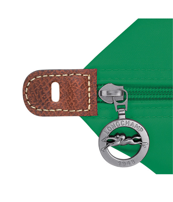 תקריב רוכסן לונגשאמפ עם מחזיק עור חום על תיק ירוק, מותג יוקרה ב-CHOZEN