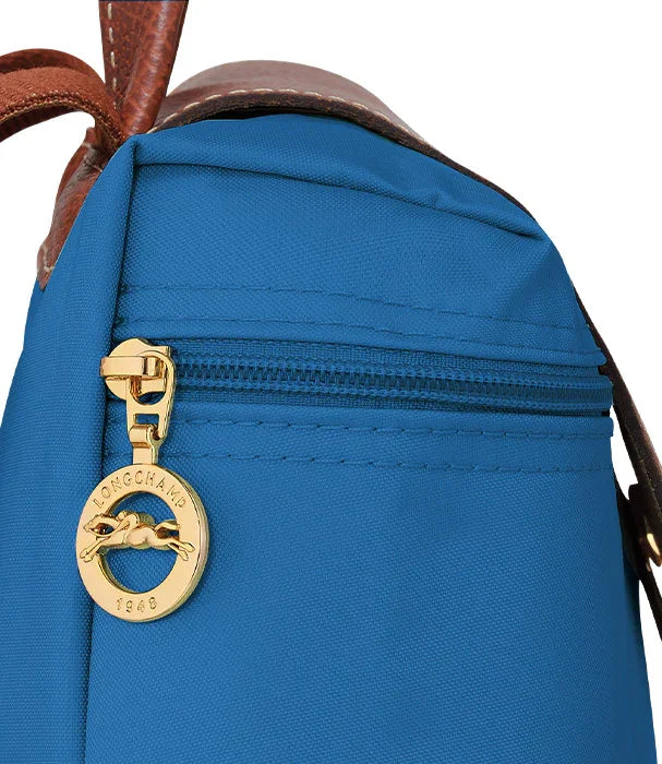 תקריב של תיק גב כחול עם רוכסן זהב לונגשאמפ, מותגים מובילים ב-CHOZEN