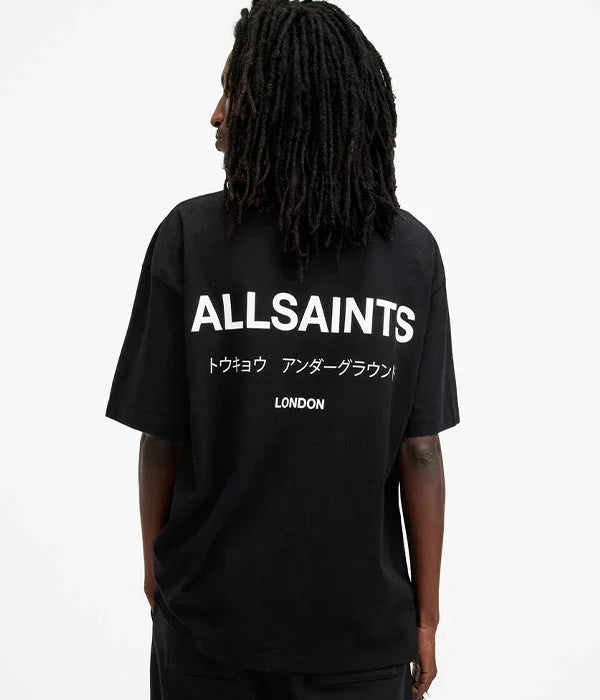 גבר עם חולצת טי שחורה, הדפסת ALLSAINTS גדולה בגב, עיצוב מודרני וטרנדי