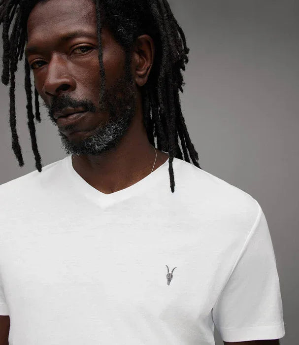 דוגמן לובש חולצה לבנה עם סמל על החזה, צילום אופנה של מותג CHOZEN