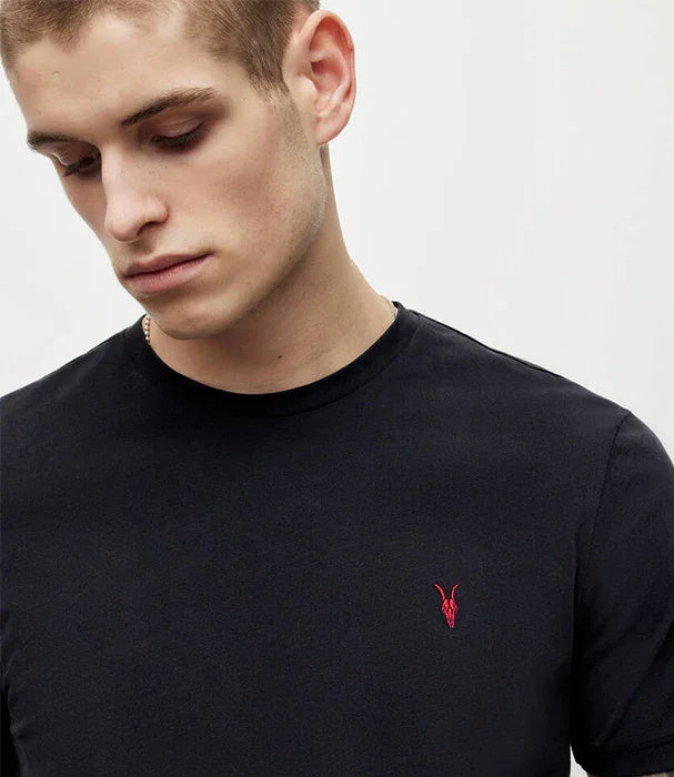 גבר לובש חולצת טי שחורה עם לוגו אדום, אופנת CHOZEN, צילום לאתר אלפא מותגים מובילים