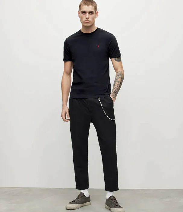 דוגמן עם חולצת טי שחורה, מכנסיים שחורים, שרשרת אופנתית ונעלי סניקרס לגבר CHOZEN