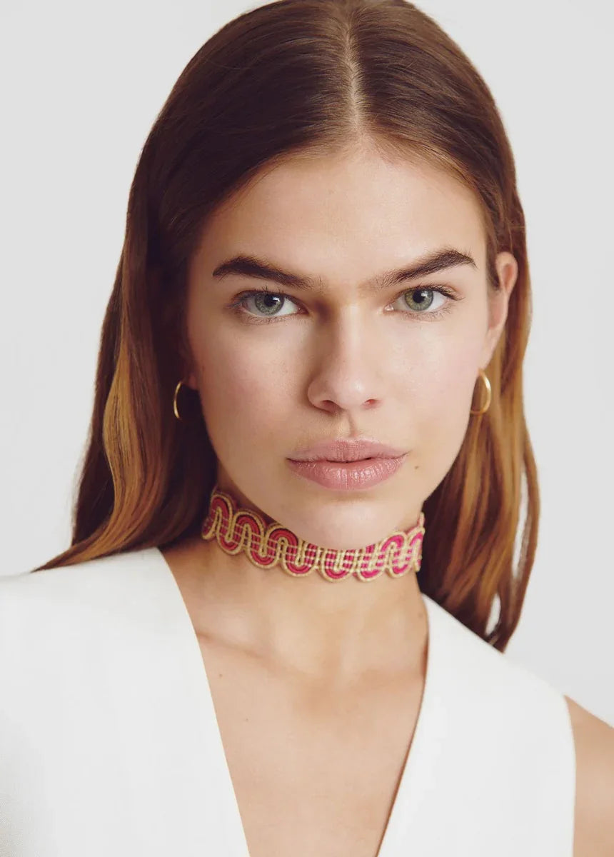 דוגמנית עם שיער חום ארוך עונדת קולר צבעוני ועגילי חישוק מזהב, צילום אופנה ל-CHOZEN