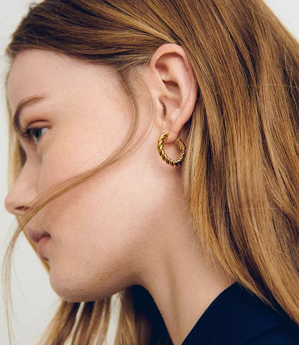 אישה עם עגיל חישוק זהב בסגנון טוויסט, תקריב לאוזן, אופנה CHOZEN קבוצה אלפא