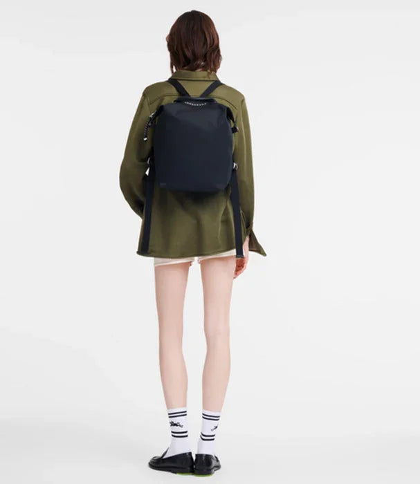 אישה עם תיק גב שחור, חולצה ירוקה ומכנס קצר, צילום אופנה לאתר CHOZEN