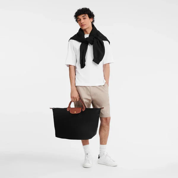 דוגמן עם תיק שחור גדול, לבוש קז'ואל אופנתי, מוצג לאתר CHOZEN יבואן מותגים