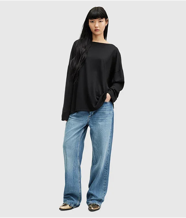 אישה לובשת חולצה שחורה וג'ינס רחב, אופנת רחוב טרנדית CHOZEN מבית קבוצת אלפא