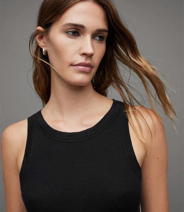 אישה לובשת גופיה שחורה אופנתית, רקע אפור, צילום לאתר CHOZEN מותגים מובילים