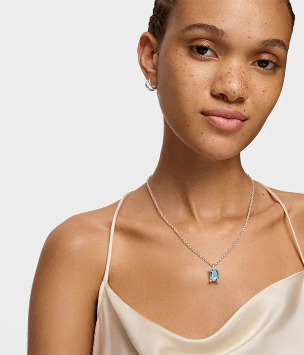 דוגמנית עם שמלה בהירה ועגילים, עונדת שרשרת כסף עם תליון אבן טורקיז, CHOZEN