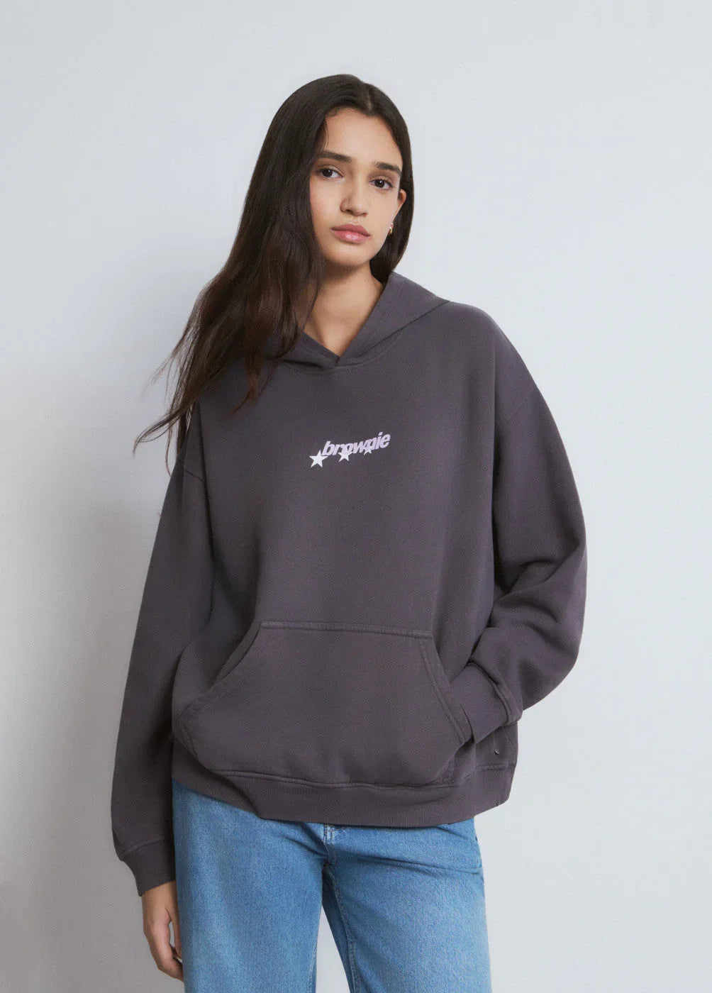 אישה לובשת קפוצ'ון אפור עם לוגו brownie, אופנת רחוב CHOZEN מבית קבוצת אלפא