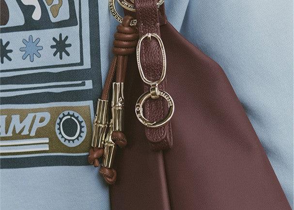 תיק עור בורדו עם אבזמים מוזהבים ליד חולצה עם הדפס, מבית CHOZEN