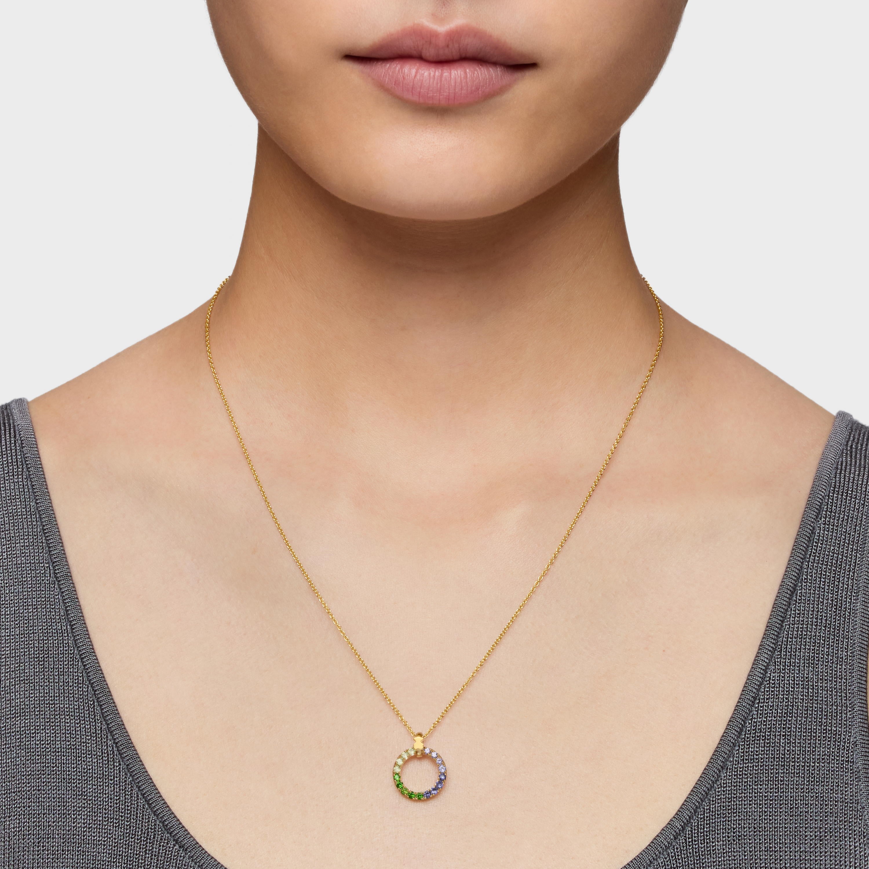 שרשרת זהב עדינה עם תליון עיגול משובץ אבני חן צבעוניות על צוואר אישה