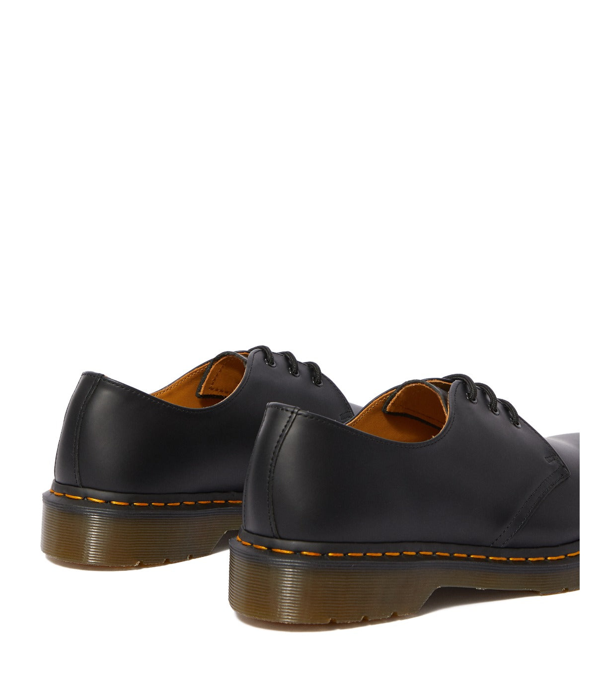 תקריב עקב של זוג נעלי DR. MARTENS GIBSON שחורות עם סוליה חומה ותפר צהוב, מבית CHOZEN