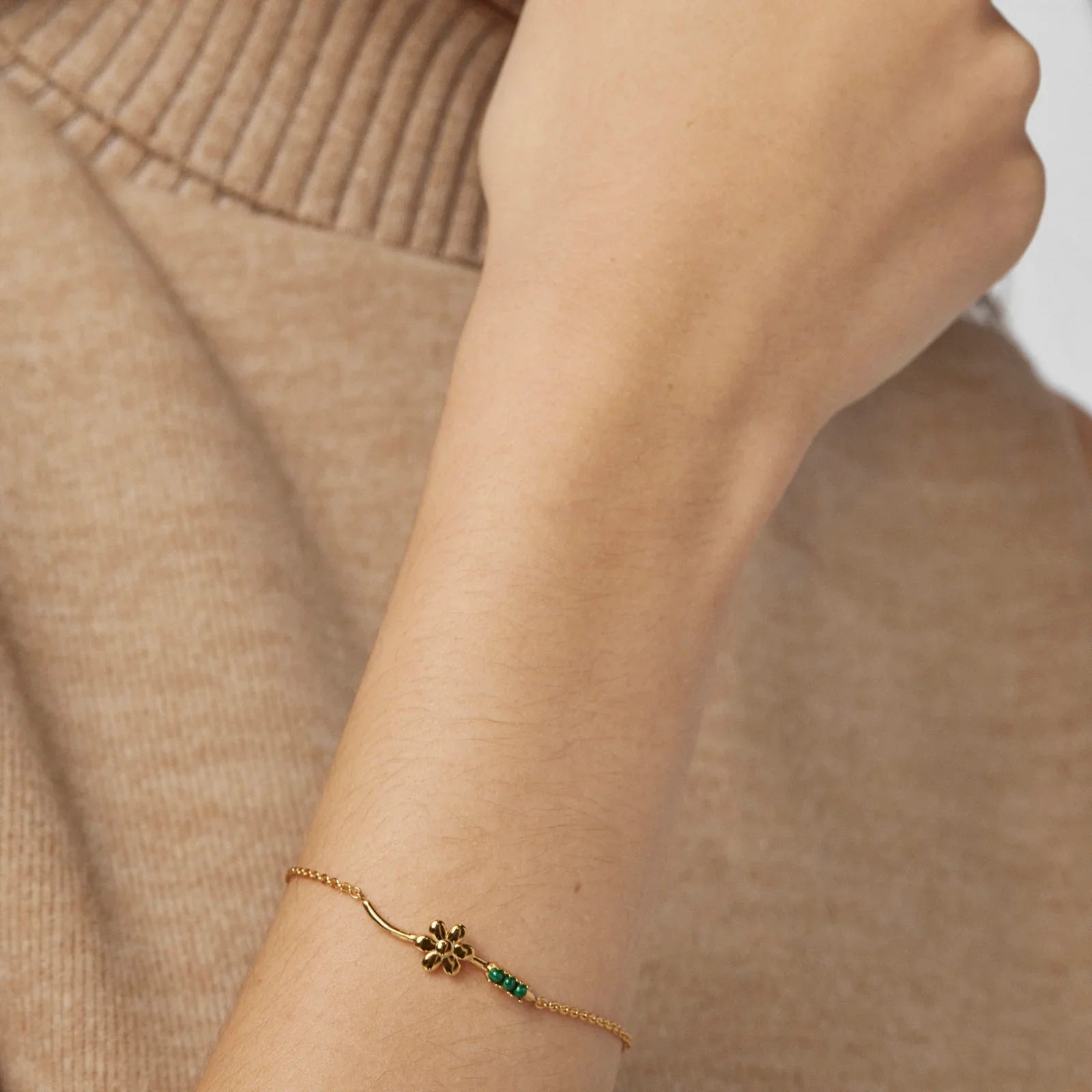 צמיד זהב עדין עם קישוט פרח ואבנים ירוקות על יד אישה, אופנה CHOZEN