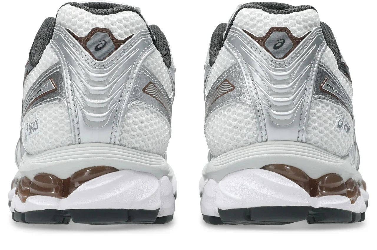 זוג נעלי ספורט לבנות עם עיטורי כסף וחום, תקריב על חלק אחורי, רשת נושמת וסוליה מונעת החלקה