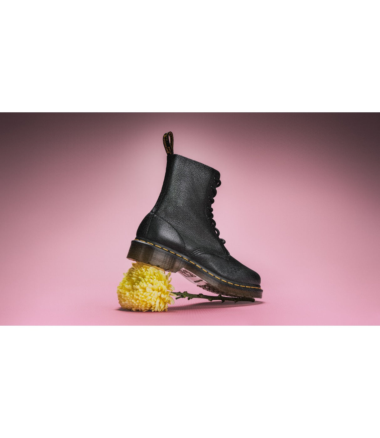 מגפי DR. MARTENS PASCAL שחורים על רקע ורוד עם פרח צהוב מתחת לסוליה, מבית CHOZEN