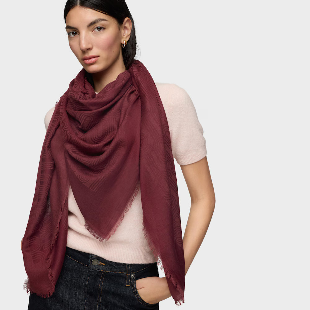אישה לובשת צעיף בורדו משולש עם דוגמה עדינה, משולב חולצה קצרה בצבע בהיר